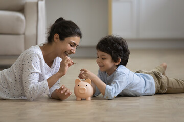 Caring young asian indian mother teaching little kid son saving money or planning future purchases,...