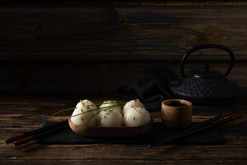 Steamed pork and prawn dim sum on slate stone on wooden table