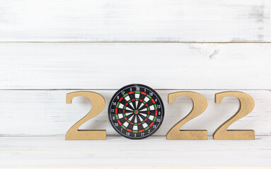 Upcoming 2022 New Year with Dartboard over white wood background, Target and Mission Conccept.