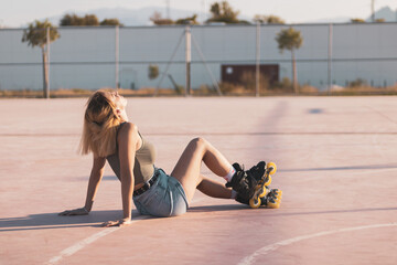 a very pretty girl riding on in-line skates on a basketball court.
