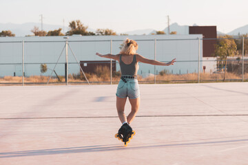 a very pretty girl riding on in-line skates on a basketball court.