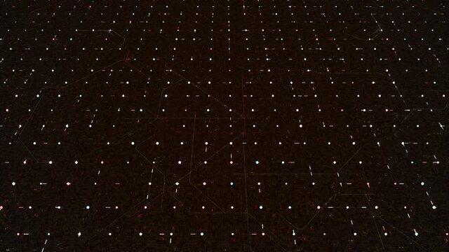 Abstract digital lines randomly moving among spots in a dark technological space. Animation. Flowing narrow stripes in a grid, seamless loop.