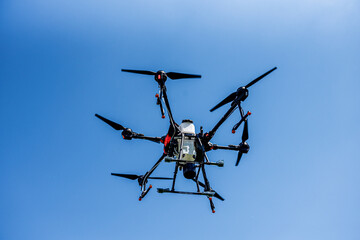 Professional agriculture drone flying in the blue sky