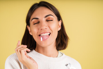 Young woman in white warm sweater taking pill happy smiling health self care