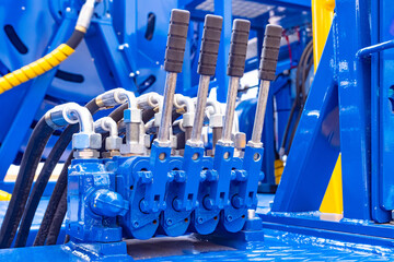 Blue hydraulic equipment close up. Levers for operating hydraulic equipment. Fragment of a blue...