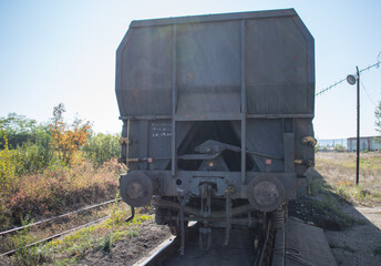 Freight car on the railway - photographed from behind. Mineral transport - concept.