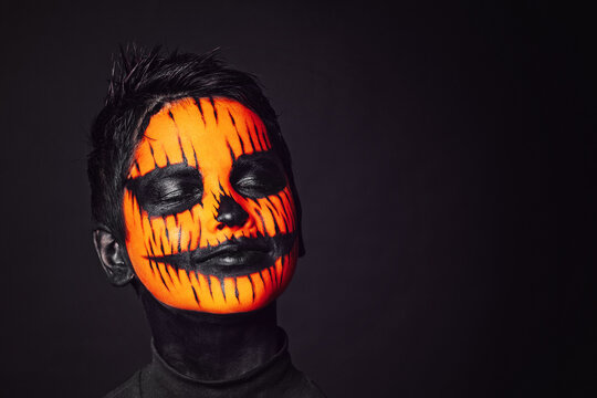 Boy with makeup on face for halloween. Scary little boy wearing skull make up - Powered by Adobe