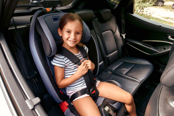 Child cute girl in a car seat is protected by seat belts. Leisure, travel, tourism.Protection...