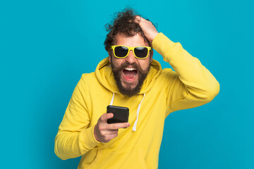 casual young man screaming, scratching head and reading emails