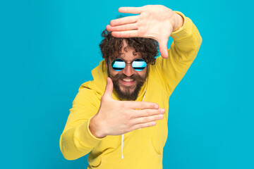 cool unshaved young guy smiling and holding hands in a framing position