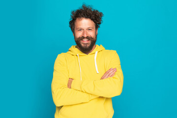 curly hair enthusiastic man crossing arms and smiling