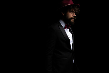 attractive businessman looking away and wearing a burgundy hat