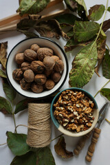 Top view of bowls full of whole walnuts and walnuts kernels                   