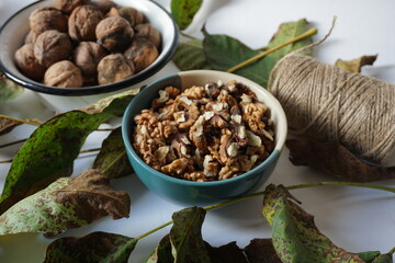 Walnuts kernels in a bowl composition with walnut leaves and jute thread role