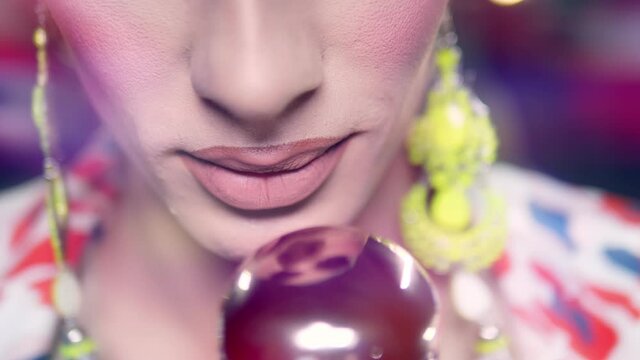 close-up of lips. male travesty artist singing into microphone on stage in safita light.