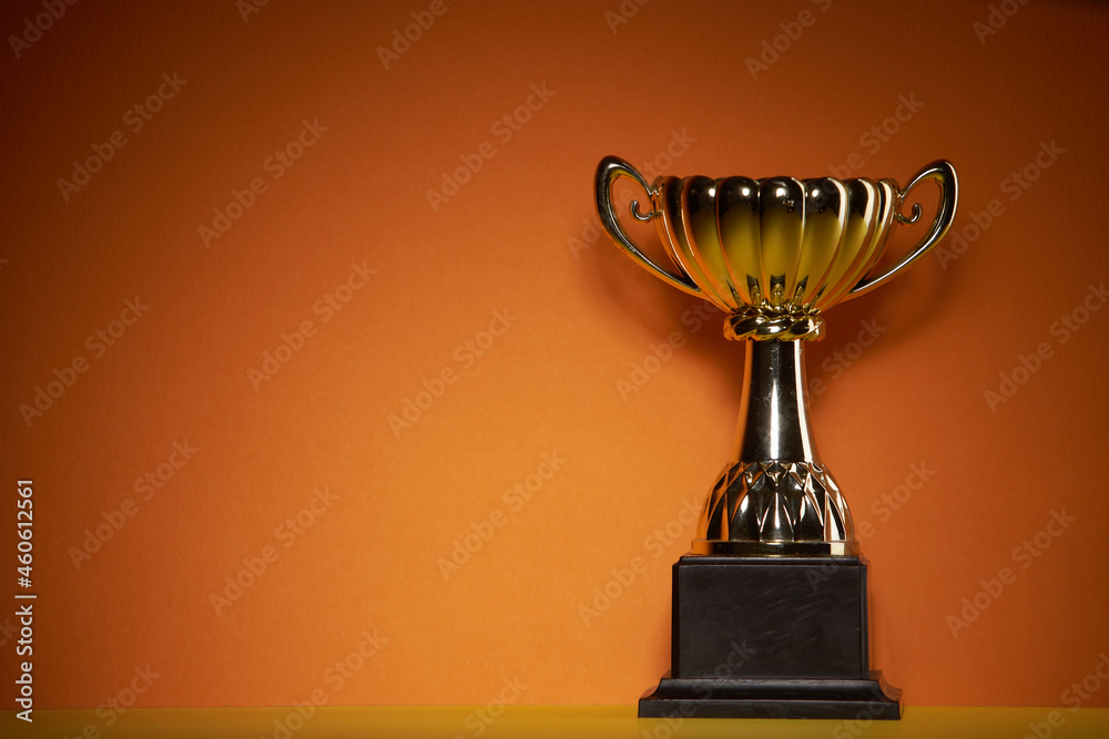 Poster close up of golden trophy on orange background