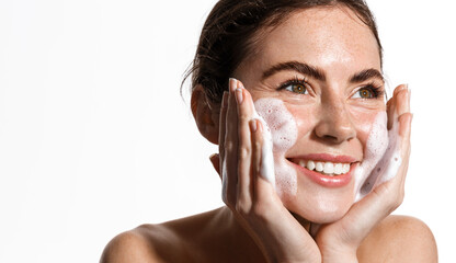 Happy female model applies foaming cleanser, has clean fresh healthy skin, smiles broadly, Girl...