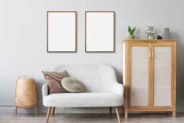 Two blank picture frame mockup on gray wall. White living room design. View of modern scandinavian style interior with chair. Home staging and minimalism concept