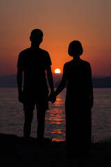 Young happy couple at sunset sea beach