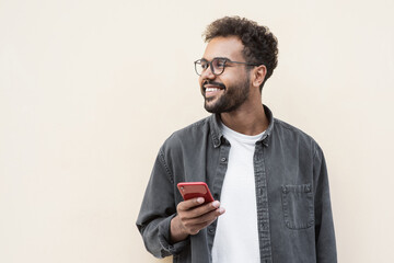 Young handsome man using smartphone in a city. Smiling student men texting on his mobile phone isolated portrait. Modern lifestyle, connection, business concept - Powered by Adobe