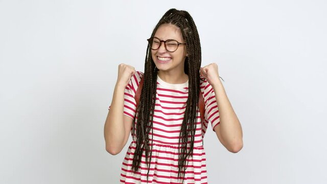 Teenager girl with braids with glasses celebrating a victory over isolated background