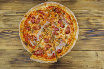 Delicious fresh pizza with sausage, mushrooms and cheese on a wooden table. Top view