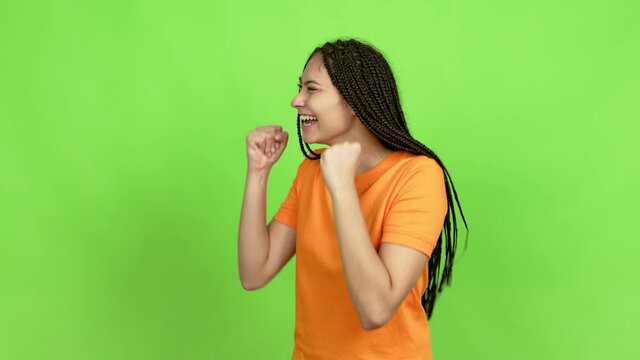 Teenager girl with braids celebrating a victory over isolated background. Green screen chroma key