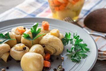 Mushrooms with vegetables and parsley in a gray plate with a napkin in close-up