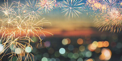 Fireworks over blur city skyline with colorful bokeh lights background.