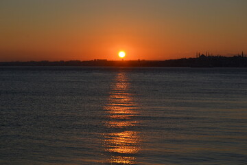 Dark sunset with orange sun,colorful sky above sea and horizon. Bosphorus coast,Istanbul.