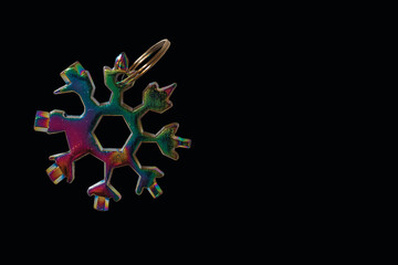 Close up view of screwdriver in form of snowflake on black background isolated.