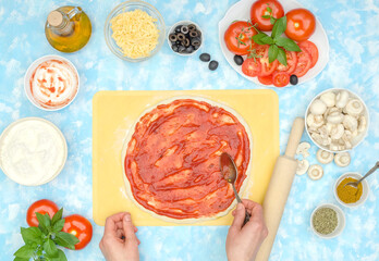 Step by step preparation of vegetarian pizza, step 3 - spread tomato sauce on the dough