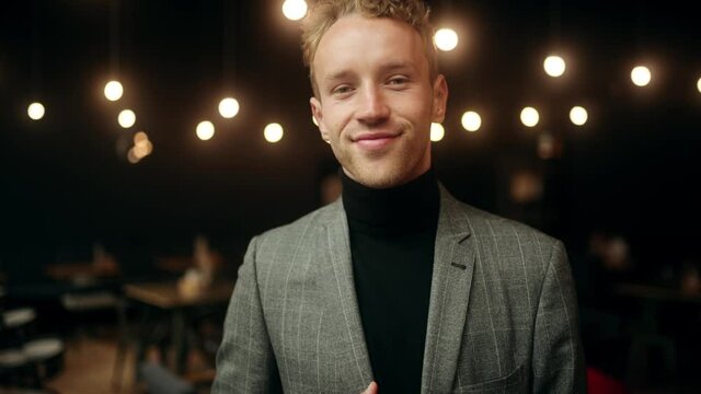 Close-up portrait of nice-looking handsome young businessman looking into camera. Attractive office worker in cafe. Successful people. High quality 4k footage