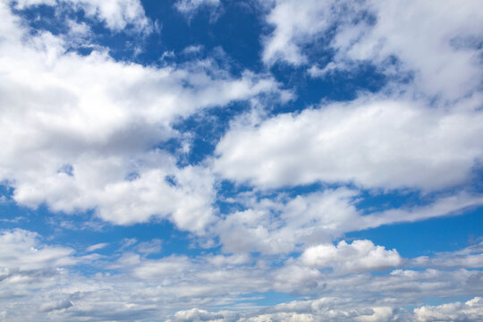 Clouds background texture of  white fluffy cumulus clouds with a blue sky cloudscape, stock photo image
