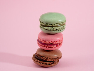 colorful macarons on pink background
