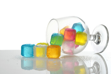 spilled colored plastic ice cubes in brandy glass