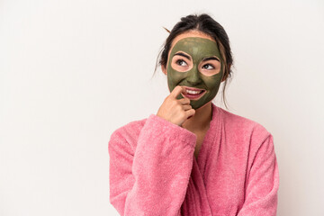 Young caucasian woman wearing a facial mask isolated on white background relaxed thinking about something looking at a copy space.