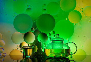 transparent glass cups with water and oily drops on colorful background 