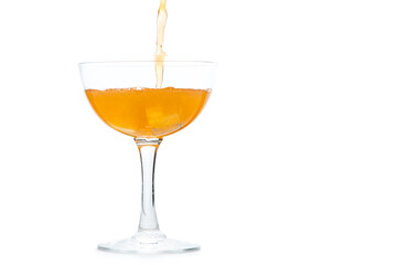 pour orange soda into Margarita glass isolated on white background,