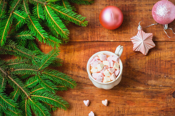 Christmas background. Composition of spruce branches Christmas balls, cup with coffee with marshmallows on a wooden background. Copy space Top view. Christmas or New Year's card. flat lay
