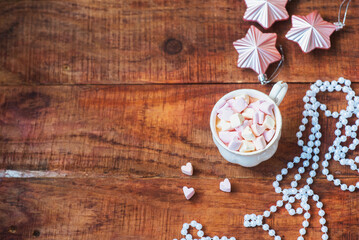 Obraz na płótnie Canvas Christmas background. Christmas balls, cup with coffee with marshmallows on a wooden background. Copy space Top view. Christmas or New Year's card. flat lay