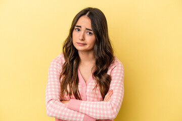 Young caucasian woman isolated on yellow background suspicious, uncertain, examining you.