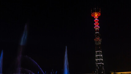 TV Tower in festival illumination. On foreground fountain with long exposure water drop. Festive concept.