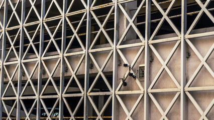 Car parking building with metal grille. Abstract steel surface with copy space. Urban concept.