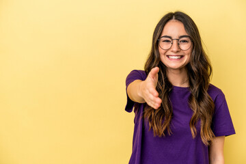 Young caucasian woman isolated on yellow background smiling and raising thumb up