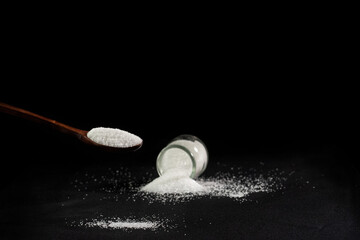 Sugar,Spoon with white sugar on a black background