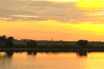 Fototapeta premium Golden sunrise over Tewaukon National Wildlife Refuge in the North Dakota tall grass prairie wetland ecosystem