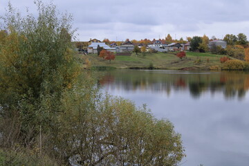 Fototapeta na wymiar a small lake and an autumn village