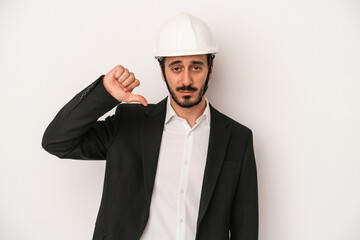 Young architect man wearing a construction helmet isolated on white background showing a dislike gesture, thumbs down. Disagreement concept.