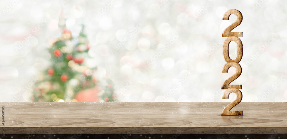 Poster happy new year and merry christmas 2022 number wood on table at blur bokeh xmas tree decor with stri